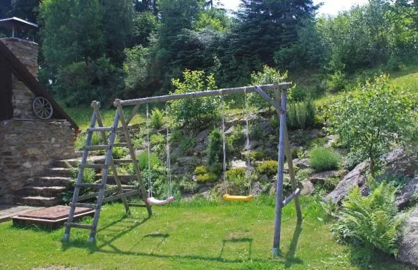 Houpačky a pískoviště pro děti na zahradě chalupy Pazderna