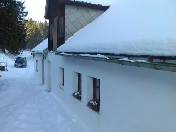 Zasněžený vchod do chalupy Pazderna v zimě